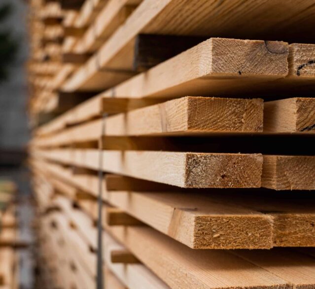 Piles of wooden boards in the sawmill, planking. Warehouse for sawing boards on a sawmill outdoors. Wood timber stack of wooden blanks construction material. Industry.